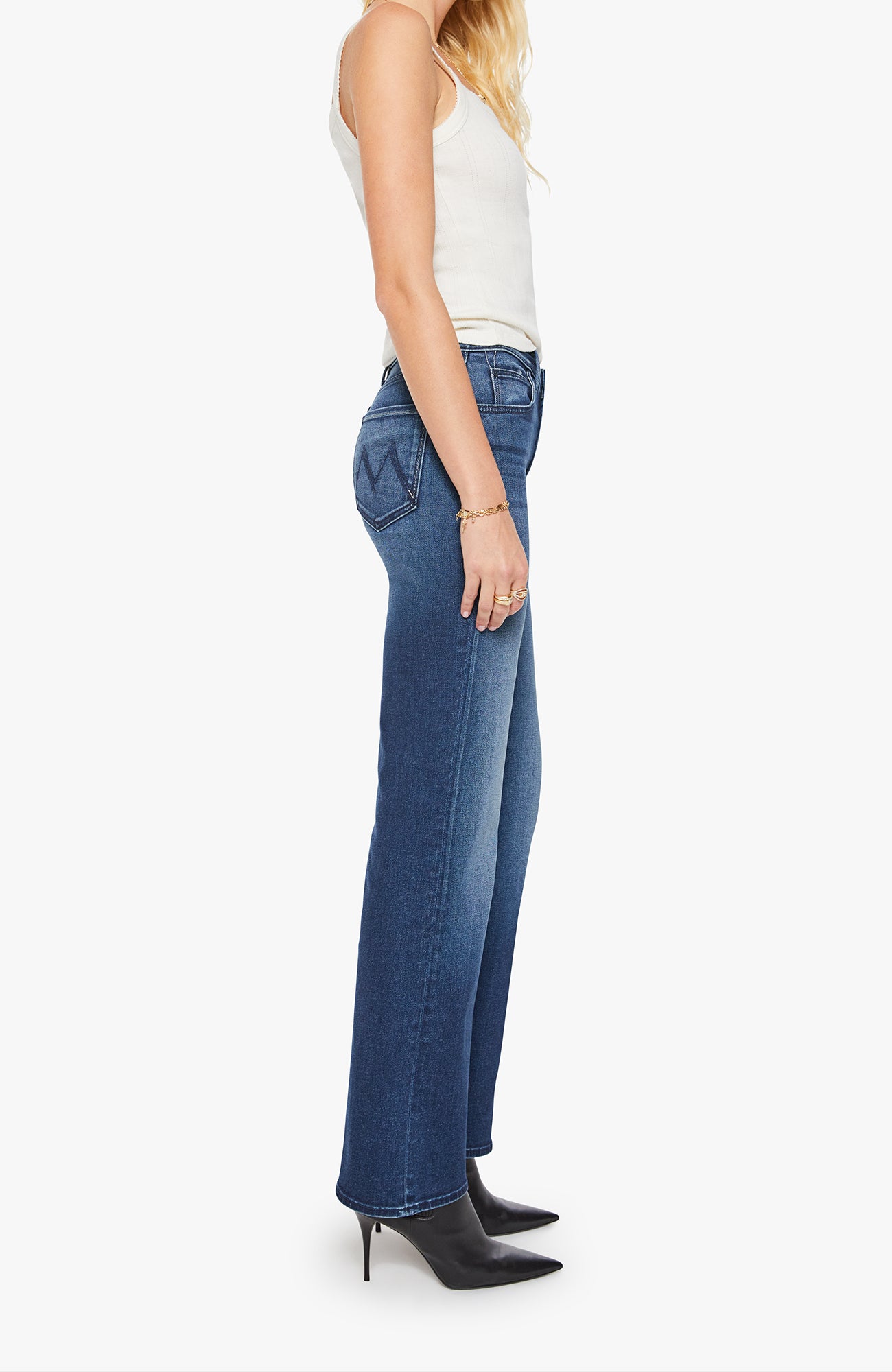 Woman wearing blue jeans and a white top on a white background