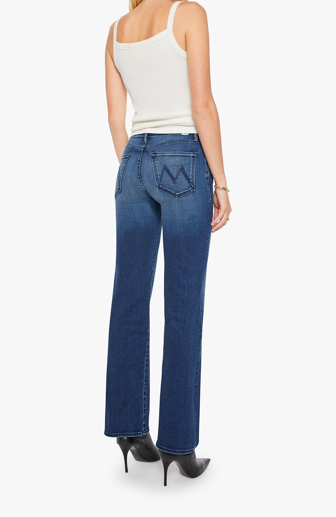 Woman wearing blue jeans and a white top on a white background