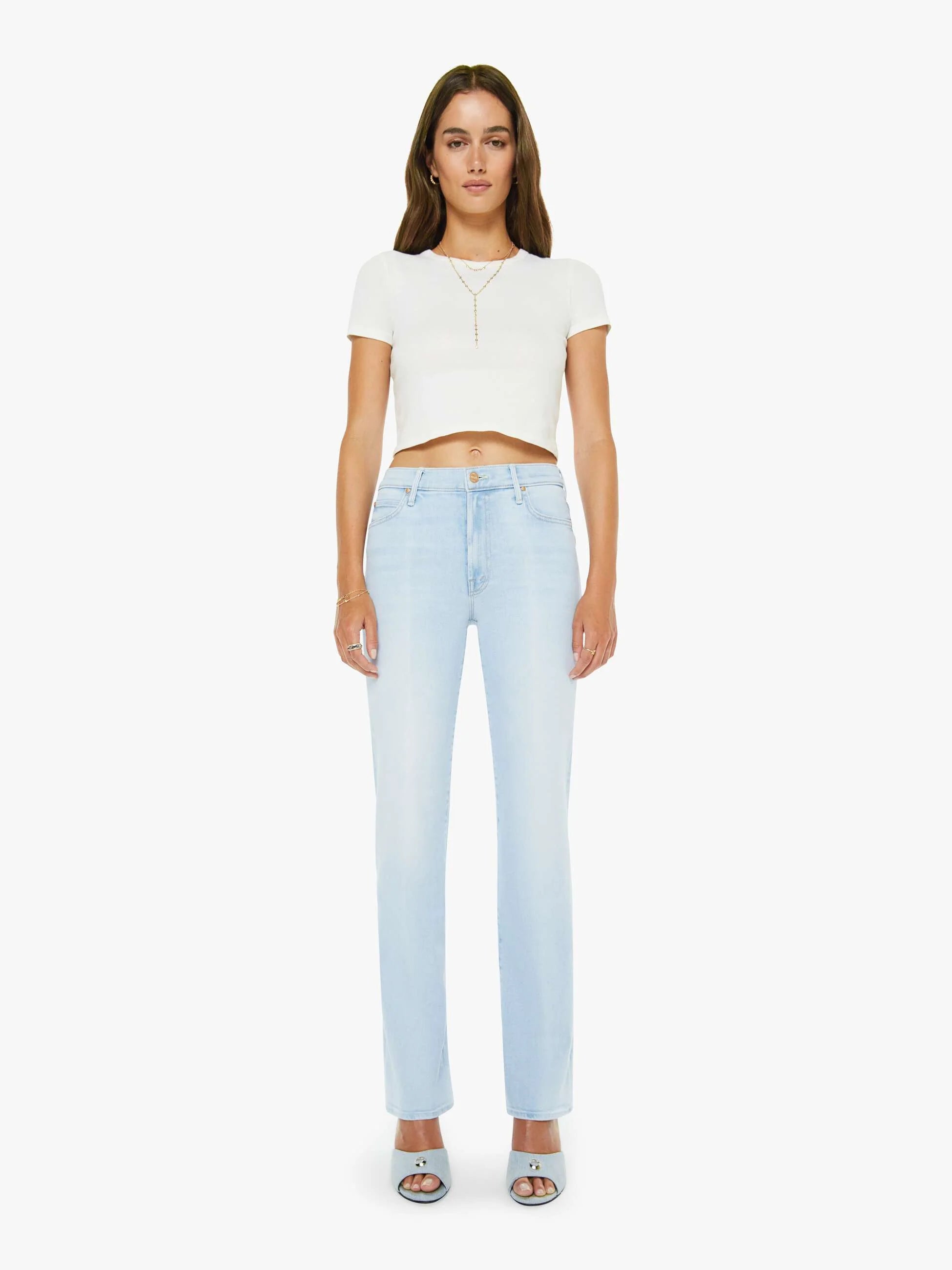 Woman wearing a white top and light blue jeans on a white background