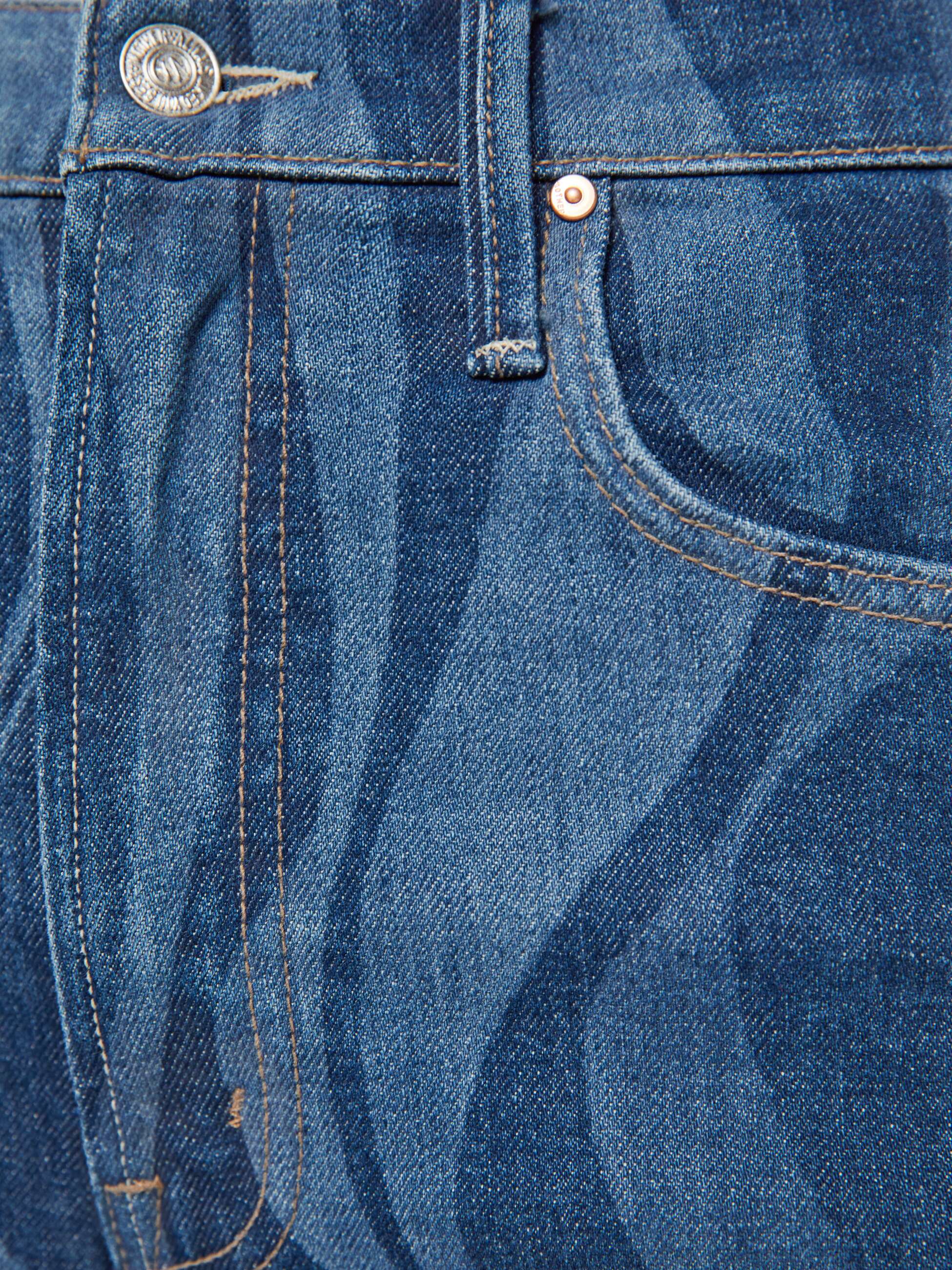 Close-up of blue denim fabric with stitching details