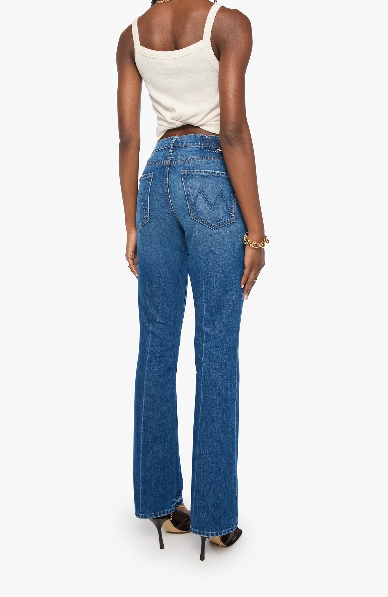 Person wearing blue jeans and a white top on a white background