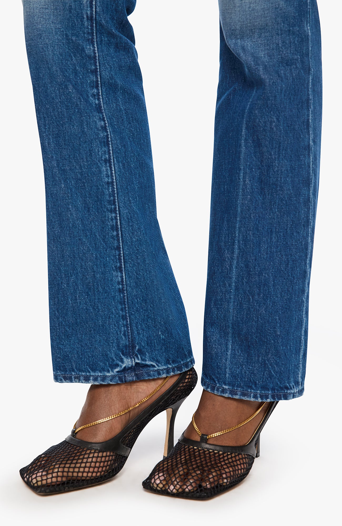 Blue jeans and black open-toe high-heeled shoes on a white background