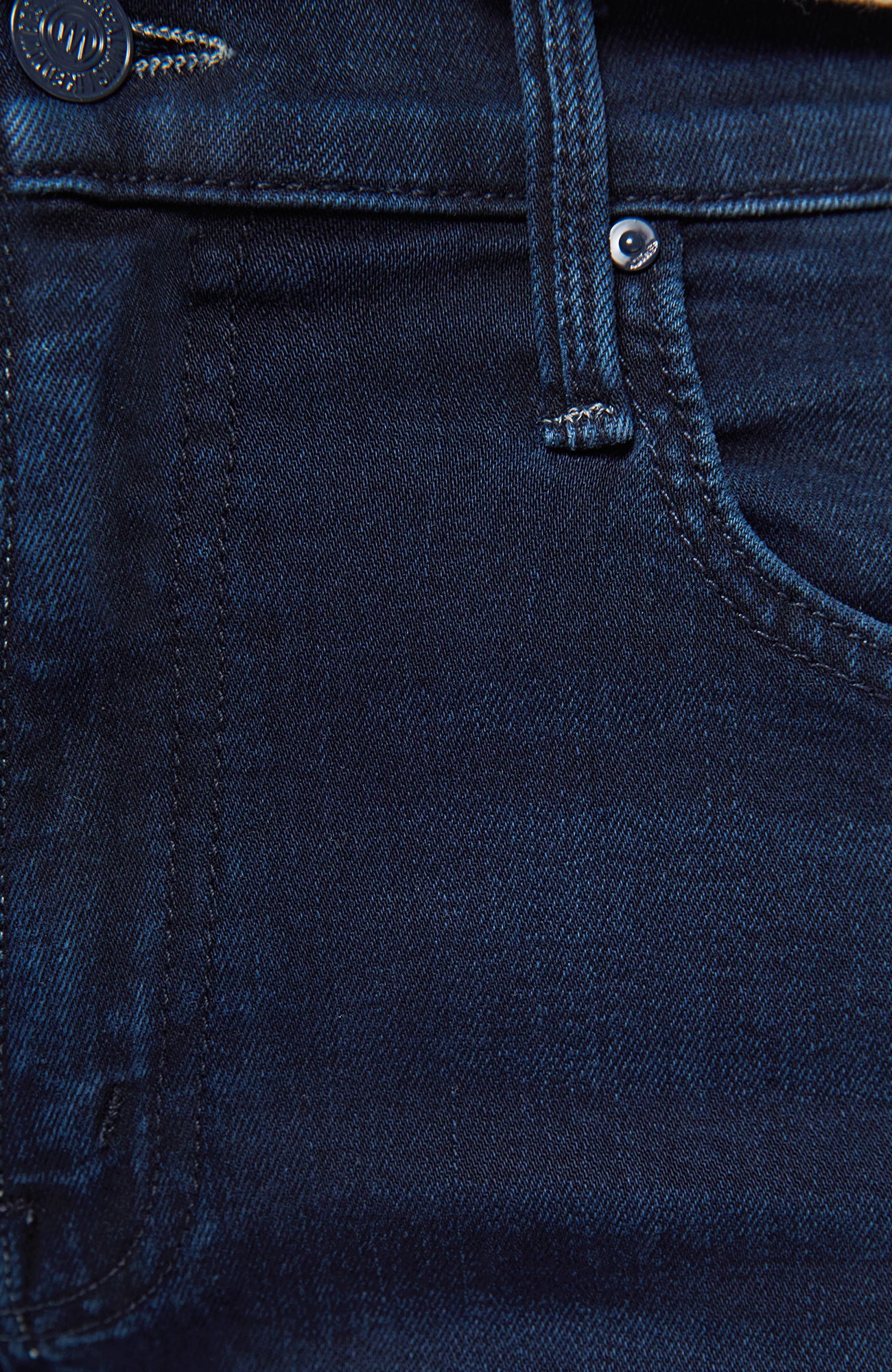 Close-up of dark blue denim fabric with stitching details
