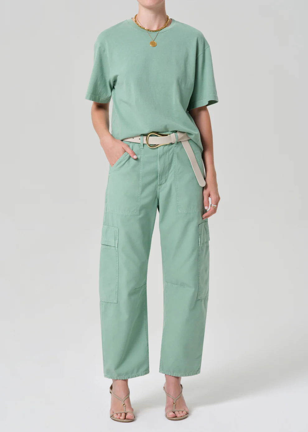 Person wearing a mint green t-shirt and cargo pants on a white background