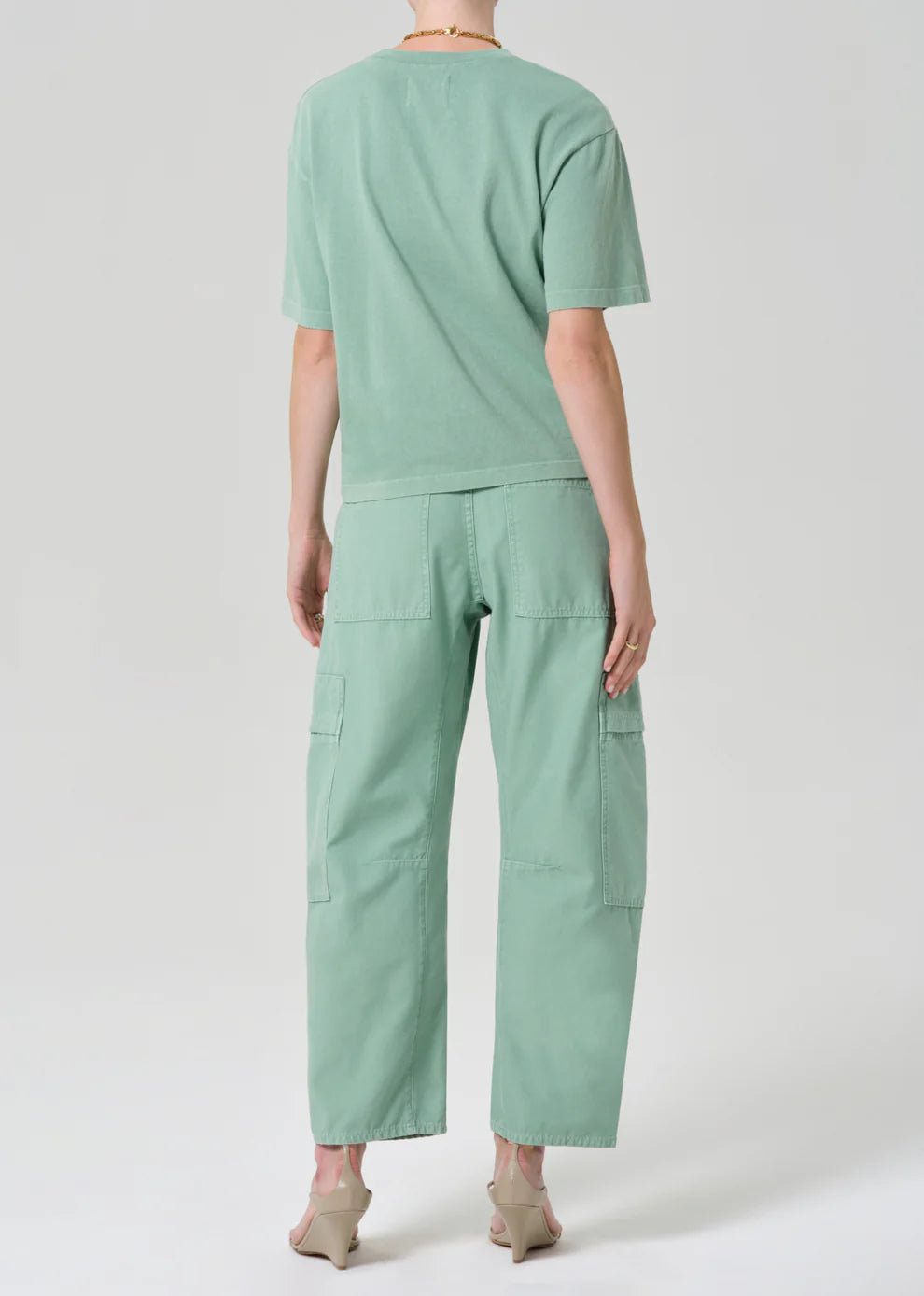 Person wearing a mint green outfit with a t-shirt and pants on a white background