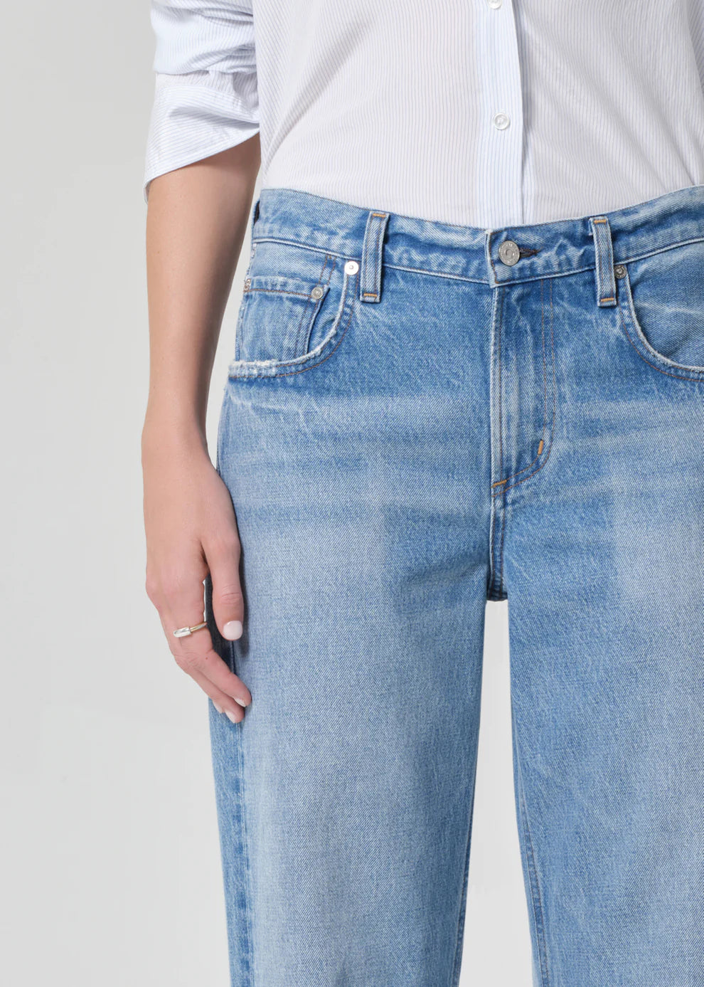Light blue jeans worn by a person on a plain background