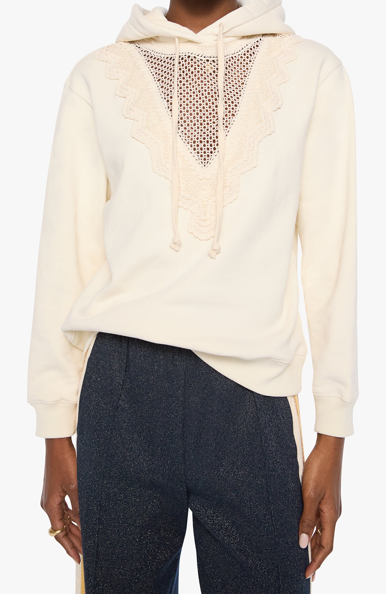 An off-white hooded sweatshirt with a sheer mesh V-neck panel and lace trim, worn by a model with dark blue pants against a light gray background.