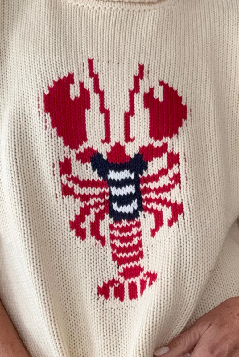 White sweater with a red lobster design on a plain background