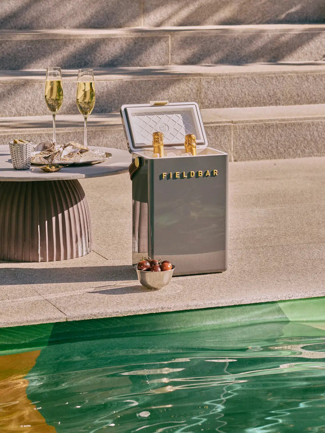 Outdoor setting with a Fieldbar refrigerator by a poolside.
