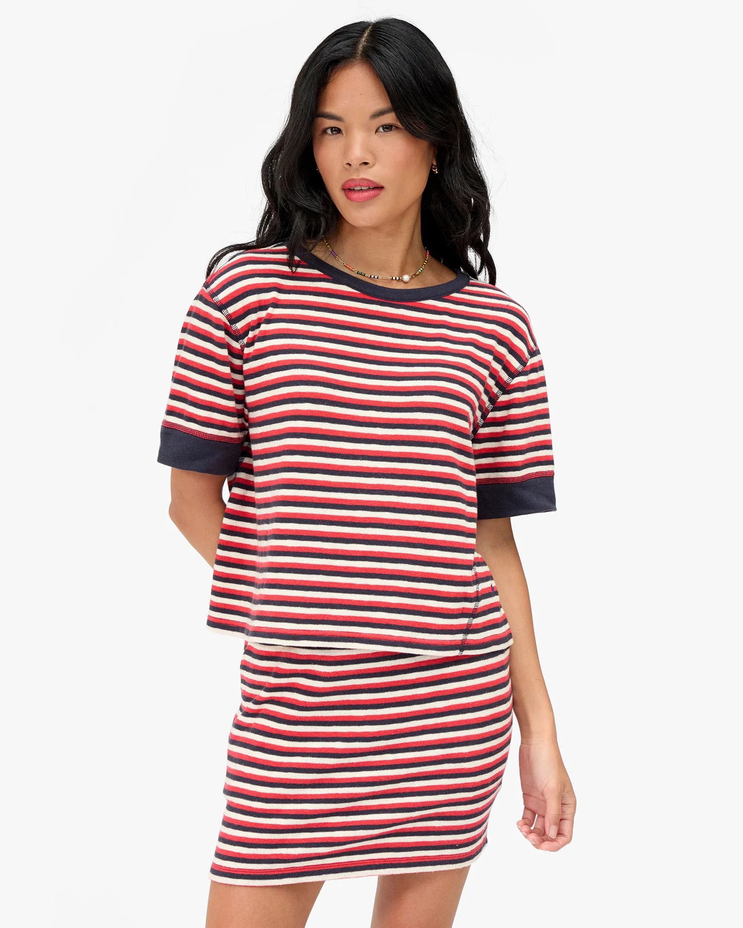 Woman wearing a red and white striped dress on a white background