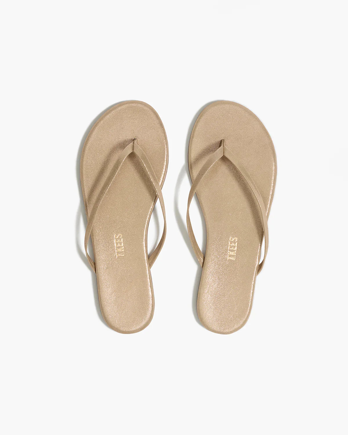 Pair of beige flip-flops on a white background