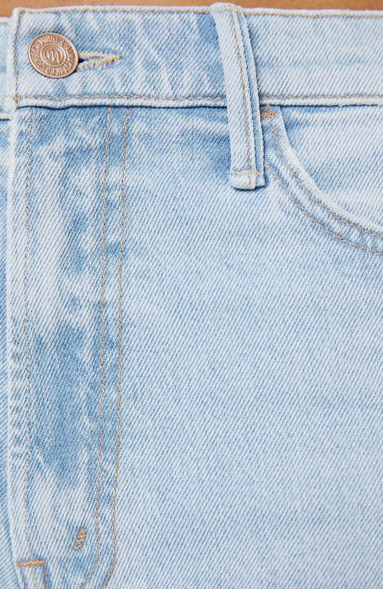 Close-up of light blue denim jeans with a brand logo on the button.