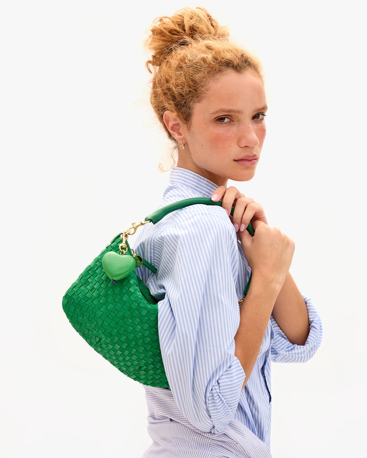 Woman carrying a green backpack on a white background