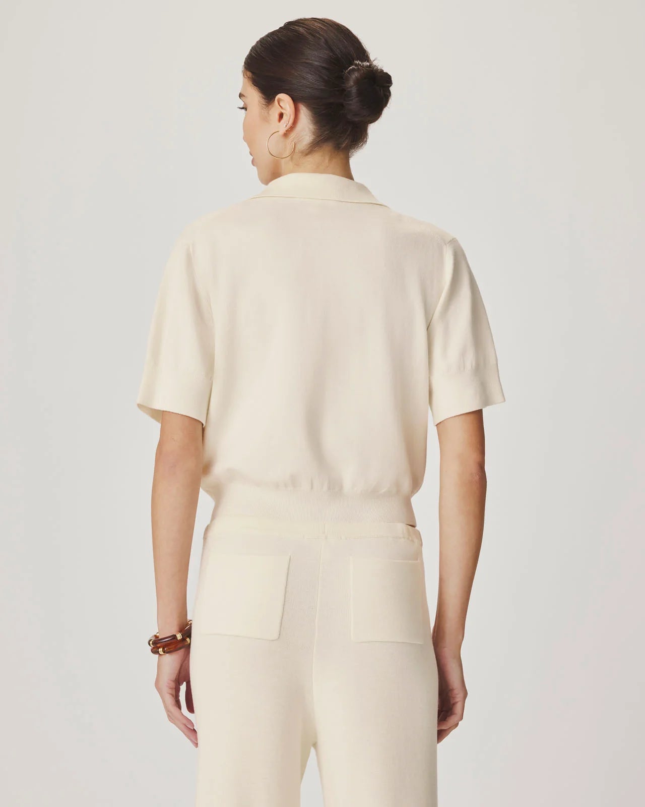 Woman wearing a beige outfit on a plain background