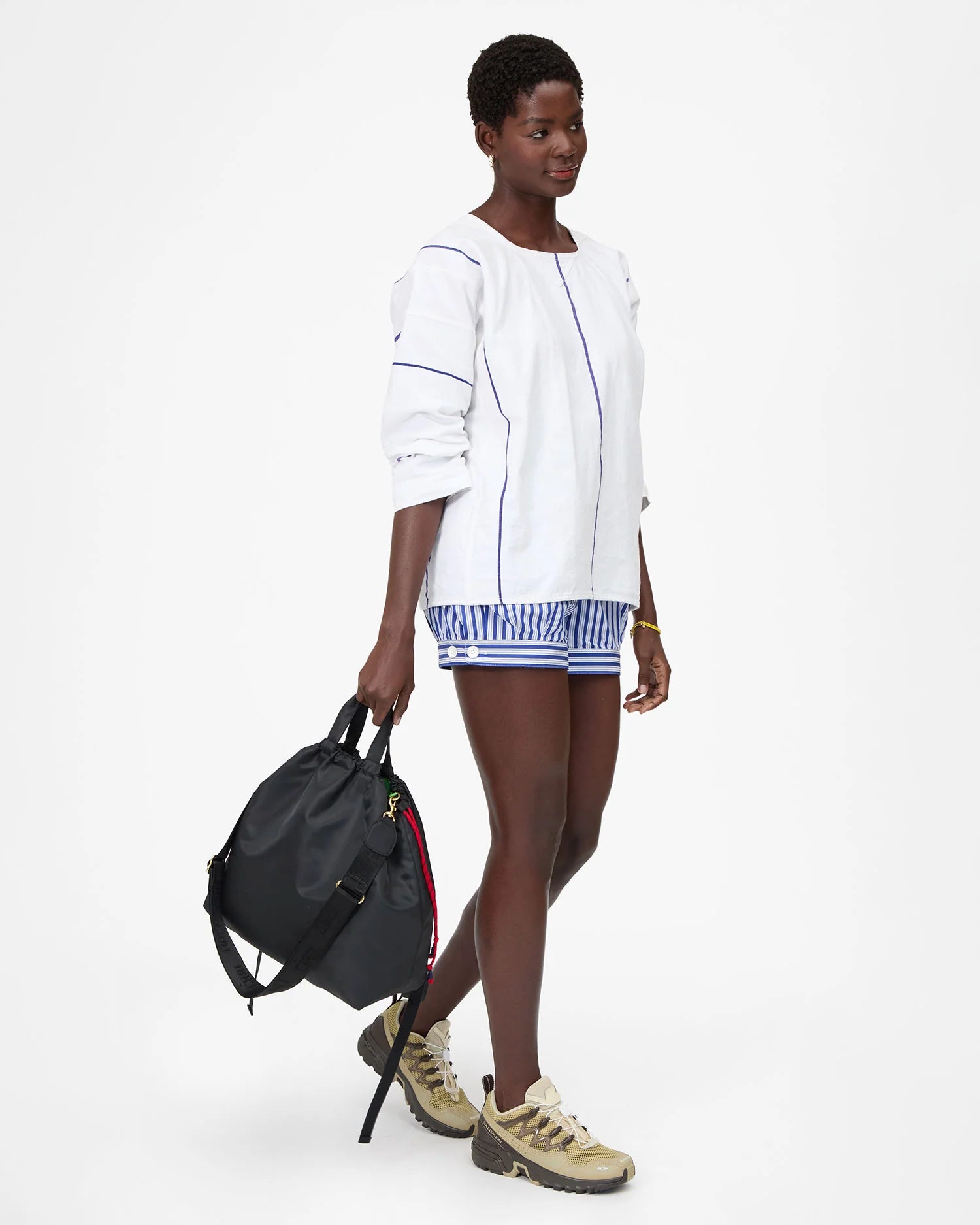 Woman holding a black backpack against a white background