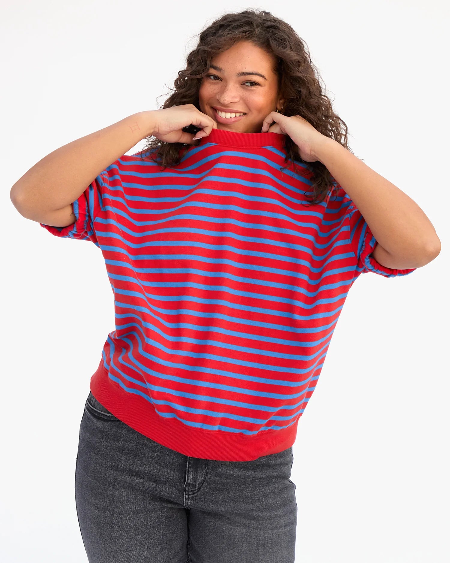Person wearing a red and blue striped sweater on a white background