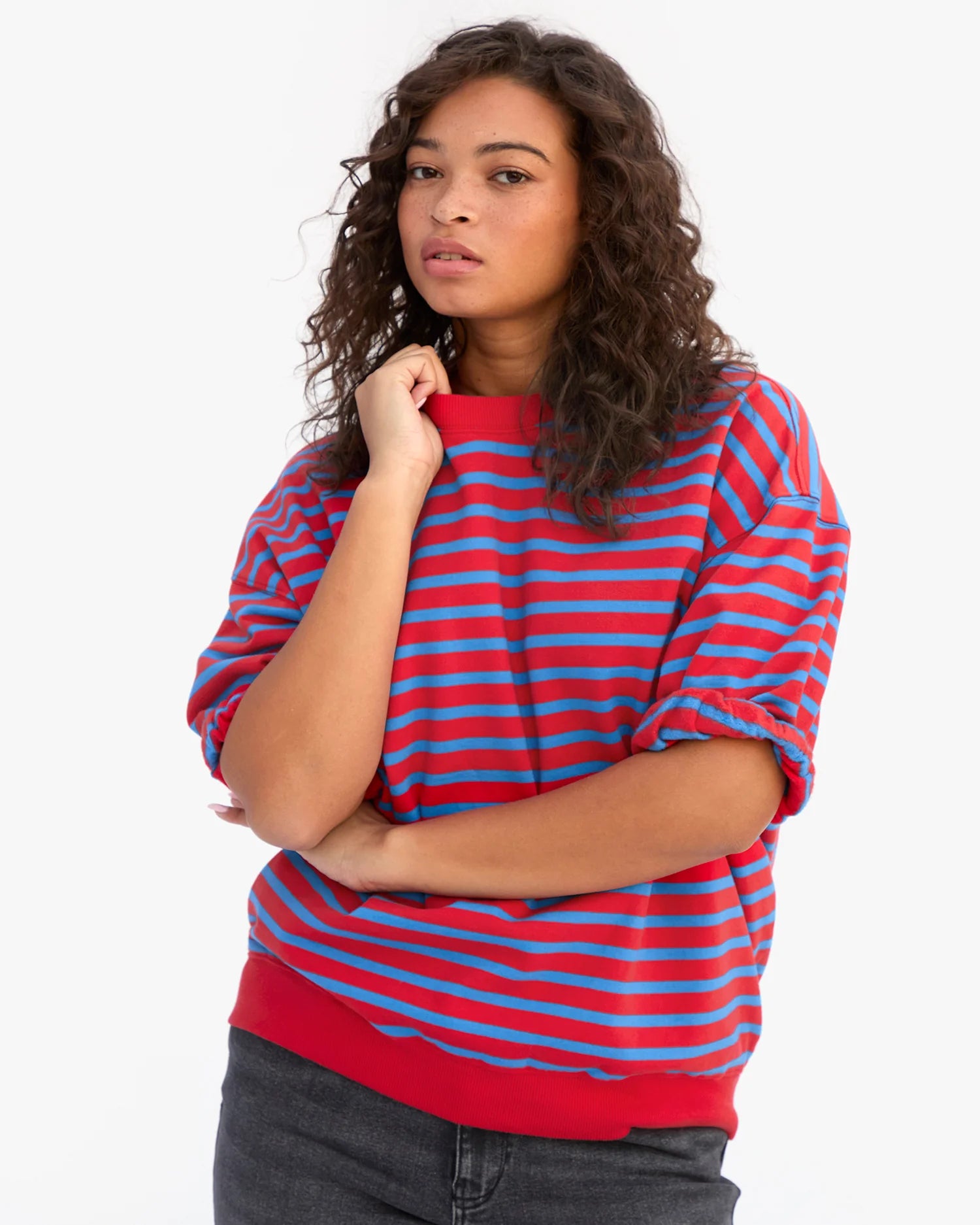Woman wearing a red and blue striped sweater on a white background