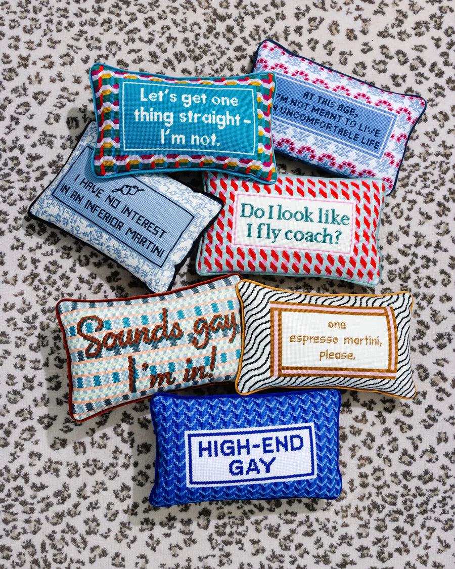 Collection of colorful pillows with humorous text on a patterned surface