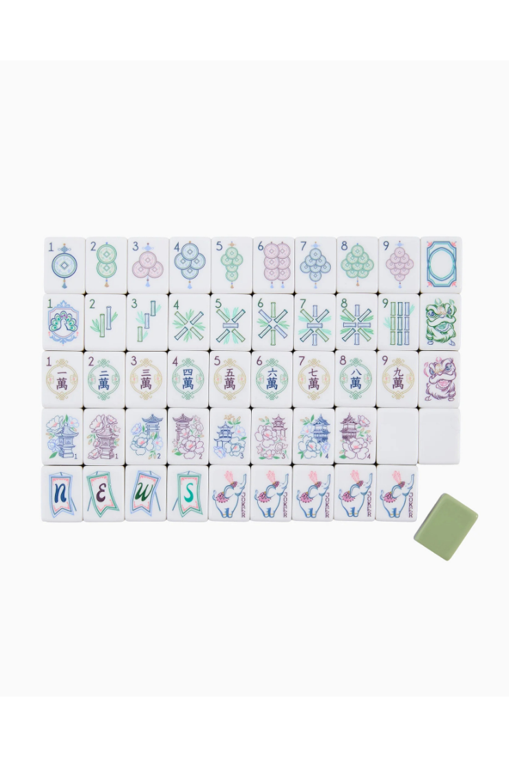 Decorative tiles with a green back and patterns on the front set on a white background.