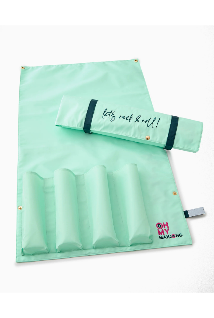 A mint green canvas roll-up organizer with five padded compartments, shown partially rolled with a black strap and the phrase 'let's rock & roll!' printed on it. The brand logo 'OH MY MAJUNG' is visible in the bottom right corner.