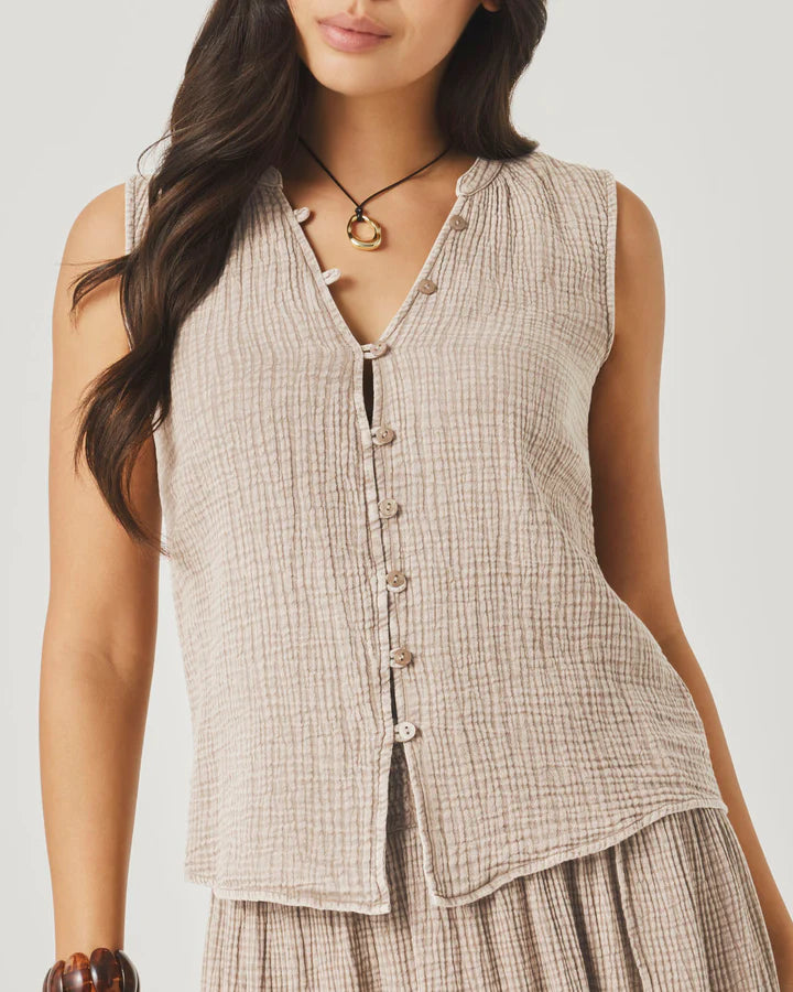 Woman wearing a sleeveless checkered top with a plain background