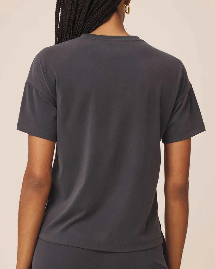 Person wearing a dark gray t-shirt against a neutral background