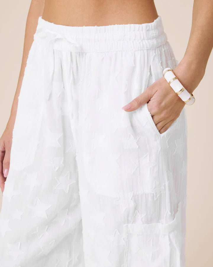 White pants worn by a person with a beige background
