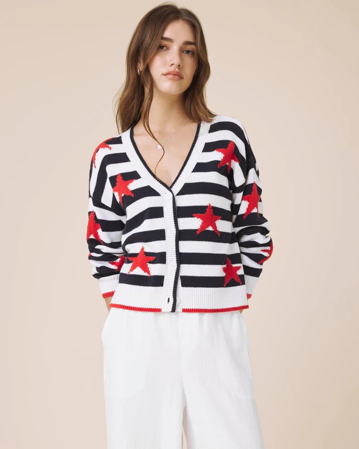 Woman wearing a black and white striped cardigan with red star patterns on a beige background