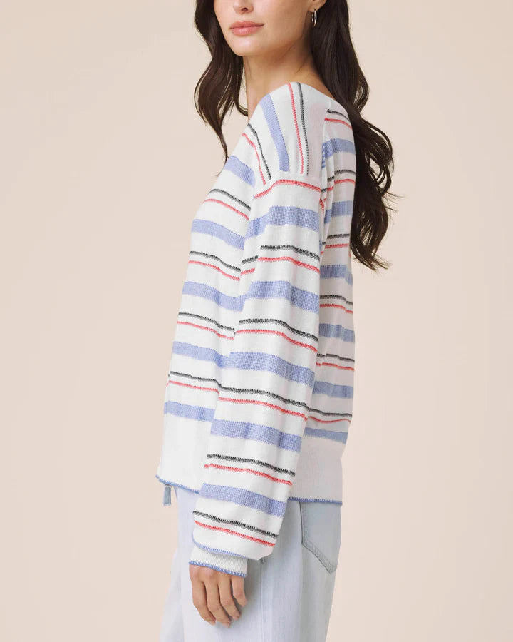 Woman wearing a striped sweater with a neutral background