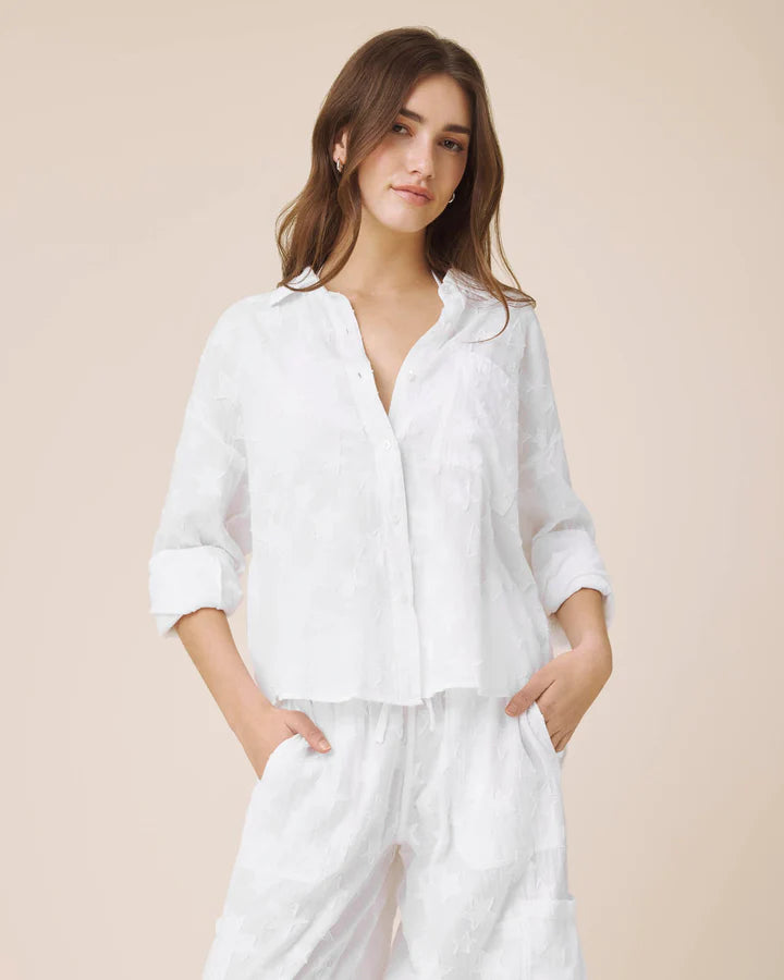 Woman wearing a white outfit on a beige background