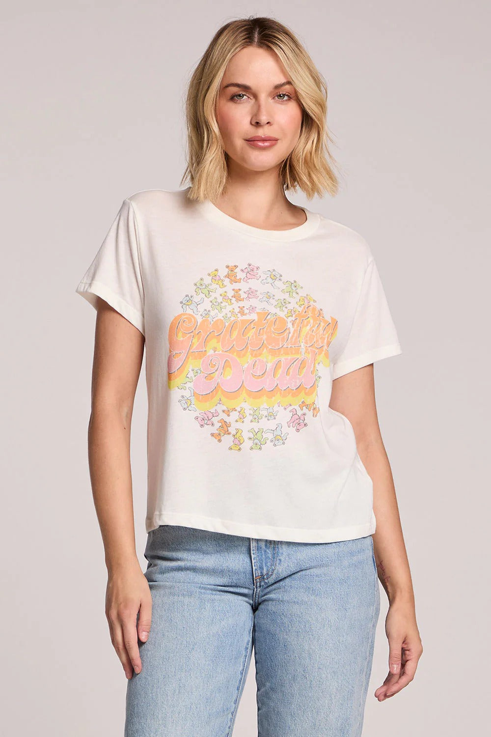Woman wearing a white t-shirt with colorful text and graphics on a plain background