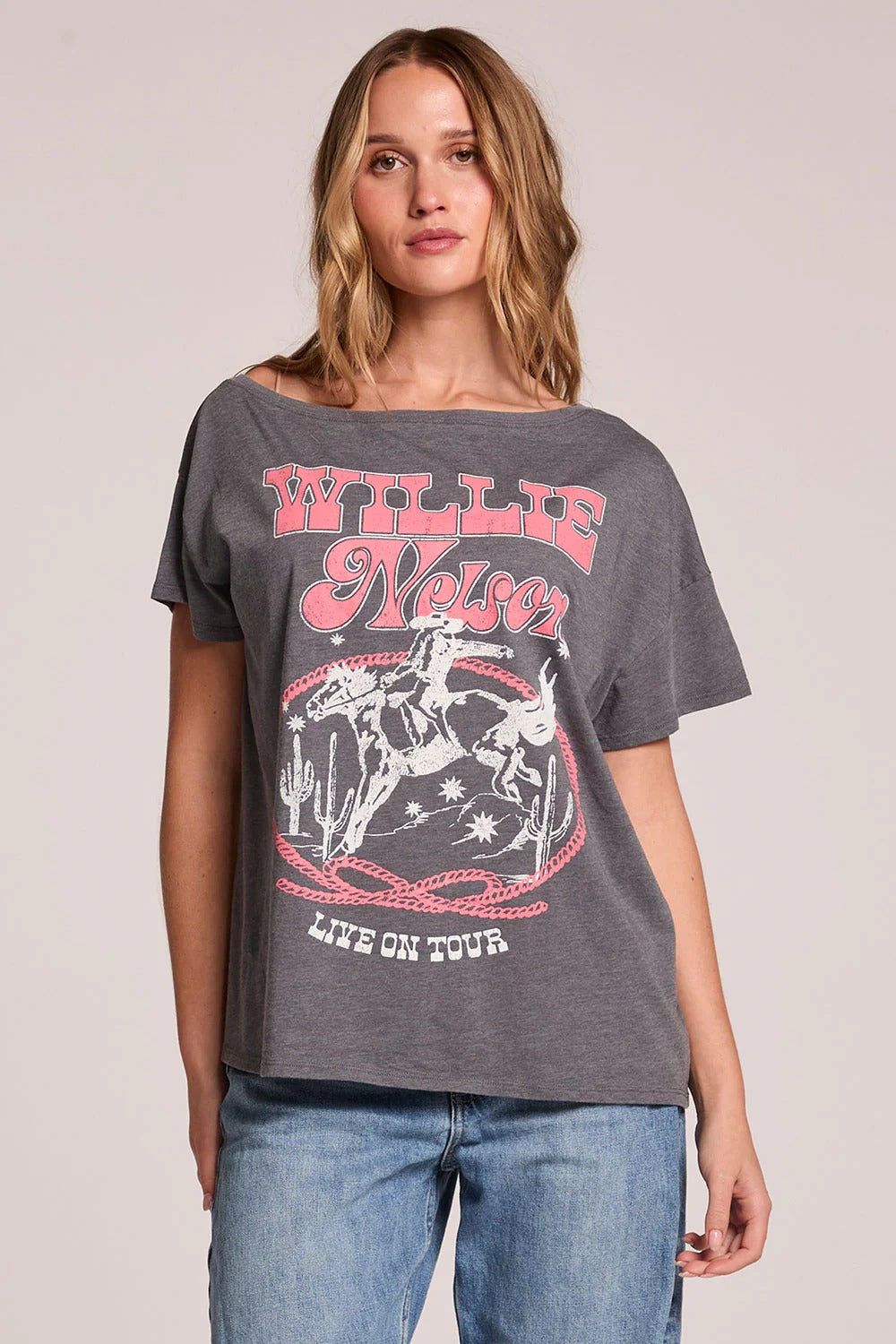 Woman wearing a gray t-shirt with 'Willie Nelson Live on Tour' graphic design.