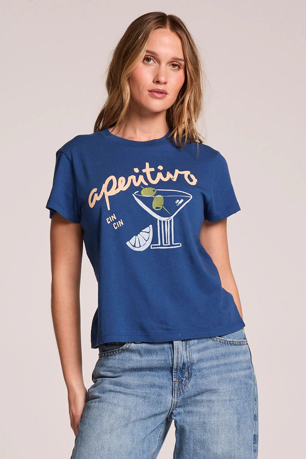 Woman wearing a blue t-shirt with 'aperitivo' design on a plain background