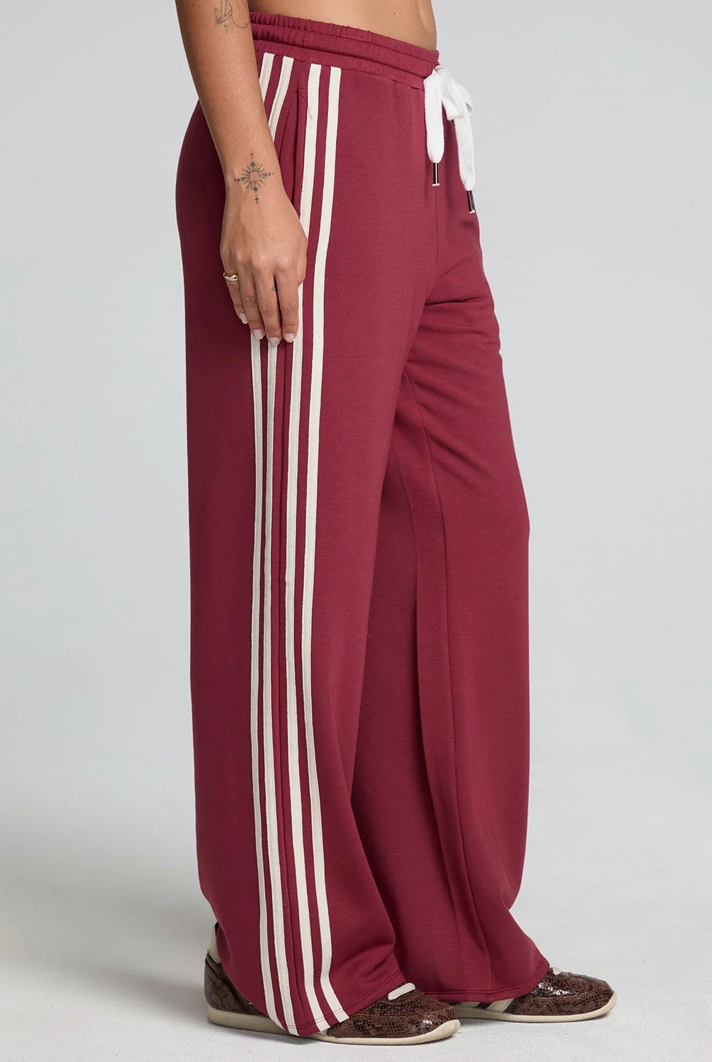 Maroon pants with white stripes on a plain background
