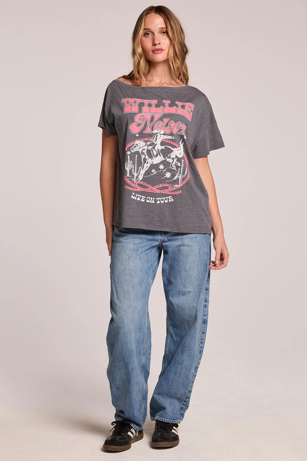 Woman wearing a graphic t-shirt and jeans on a plain background