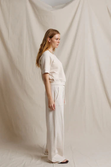 Woman wearing a white outfit against a plain background
