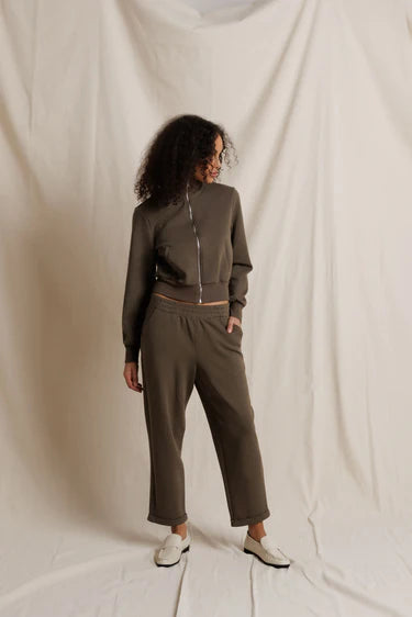 Woman wearing a green tracksuit against a plain background