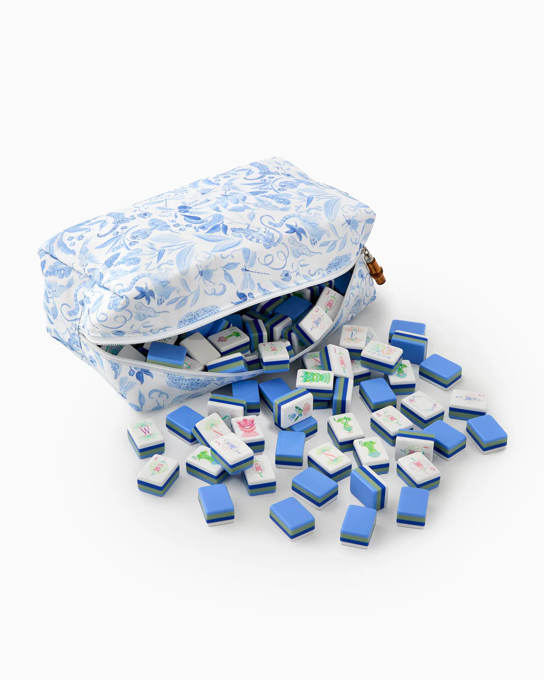 Miniature blue and white tiles spilling out of a patterned bag on a white background