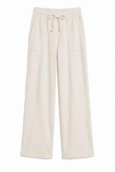 A pair of wide-leg lounge pants in a light cream or off-white color, featuring an elastic waistband with a drawstring and two front patch pockets, shown against a plain white background.