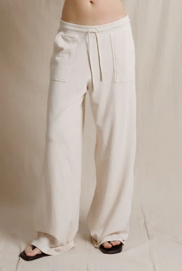 Beige wide-leg pants worn by a person on a neutral background