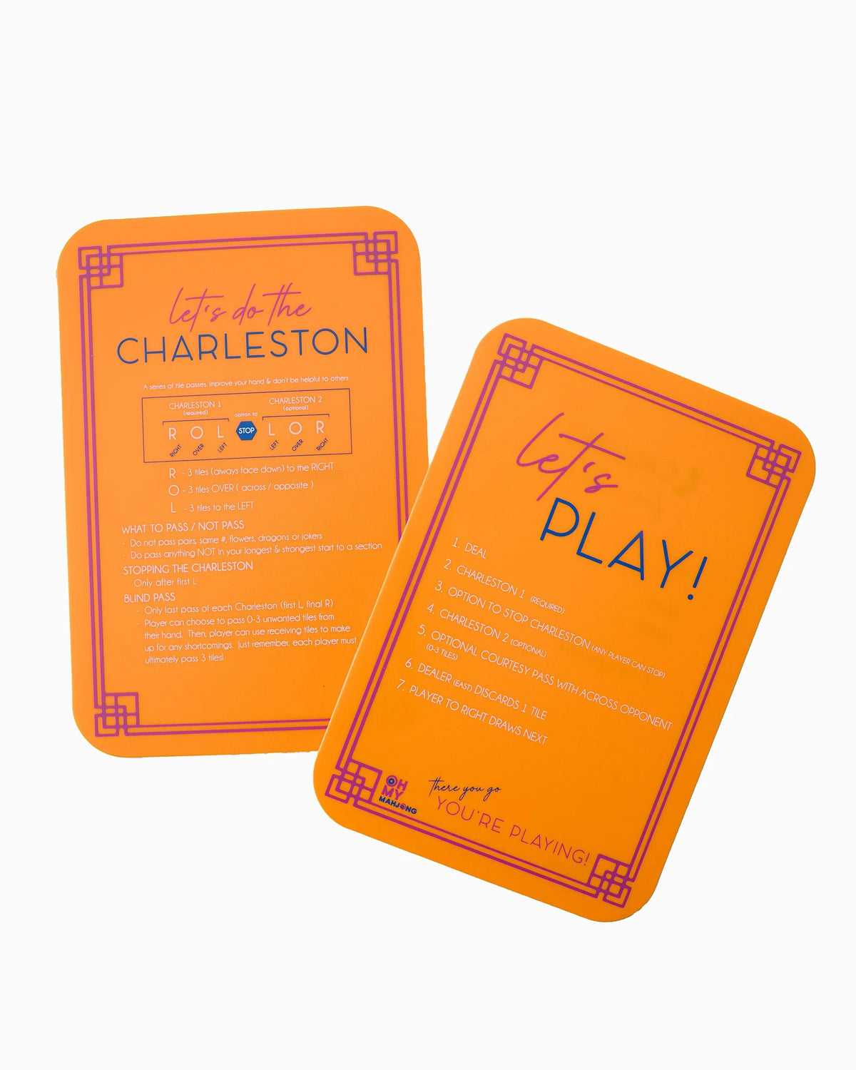 Two orange metal travel cards for Rollon Dream Vacation 2025, displayed on a clean white background. One card shows the front with purple text reading 'let's PLAY!' and a list of activities, while the other shows the back with detailed travel information.