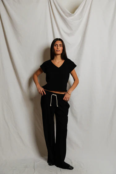 Woman wearing a black outfit against a plain white background