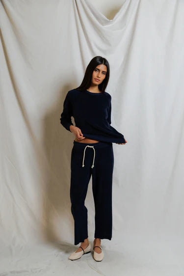 Woman wearing a navy blue outfit with a white background