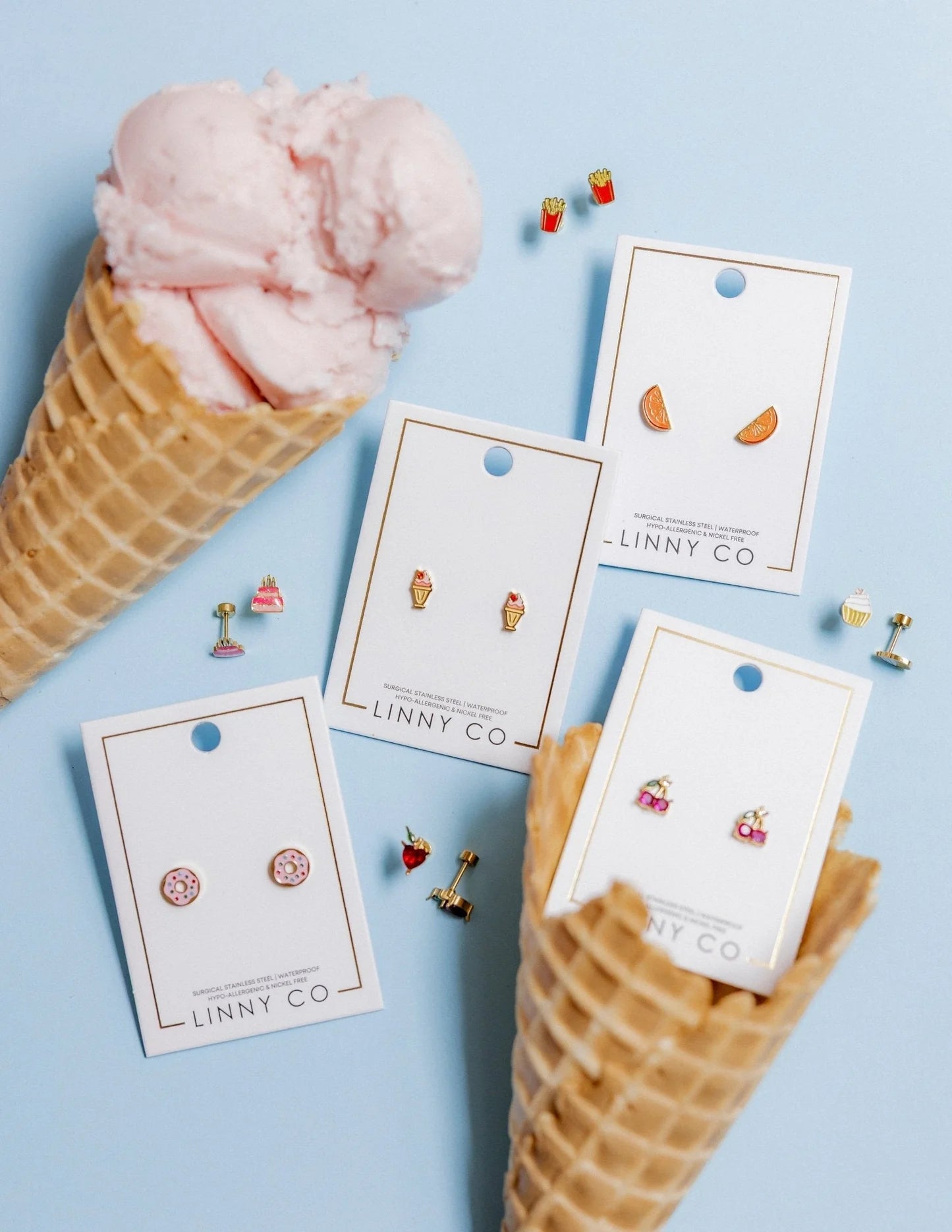 Earring cards with earrings on a blue background with ice cream cones.