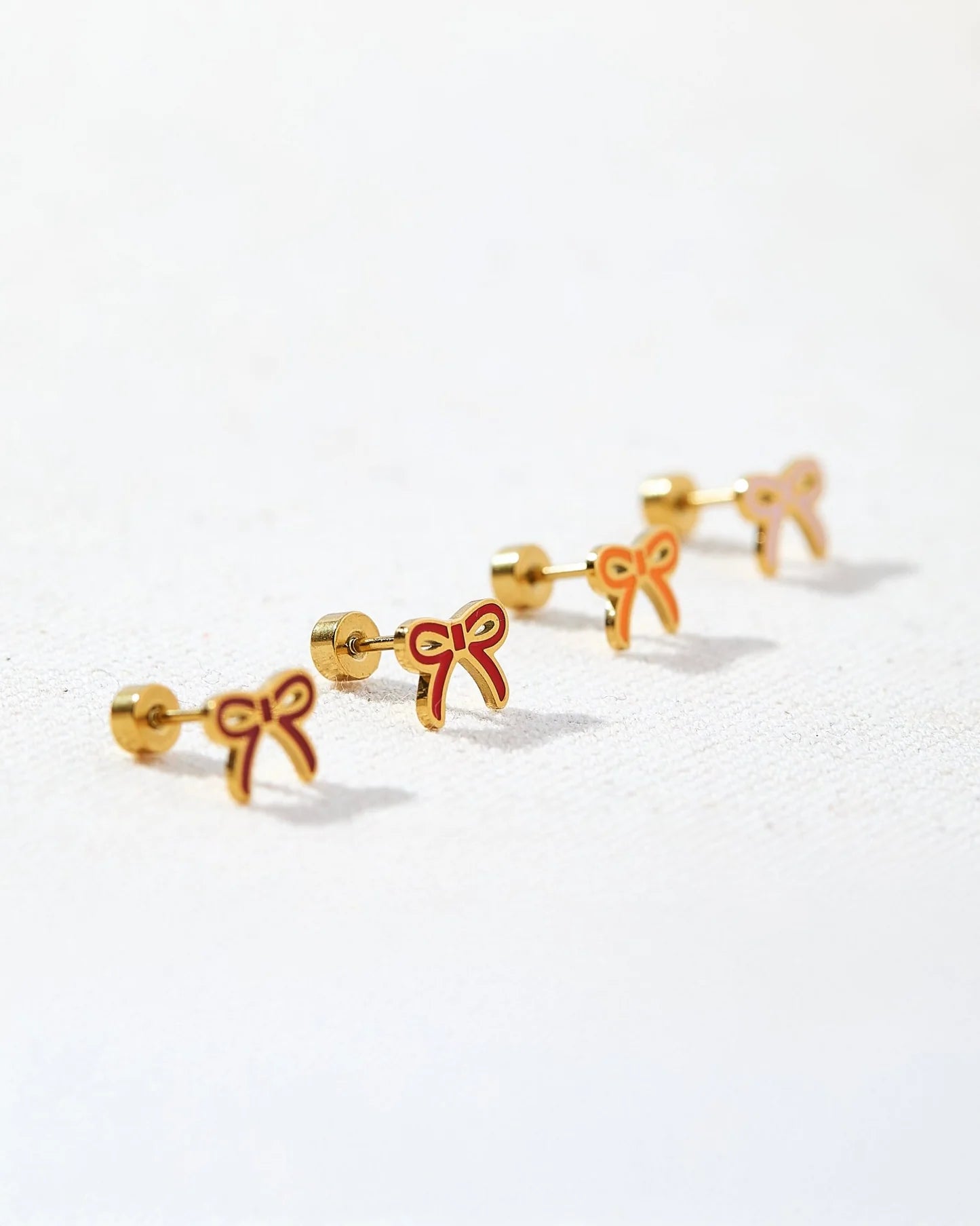 Gold bow-shaped earrings on a white background