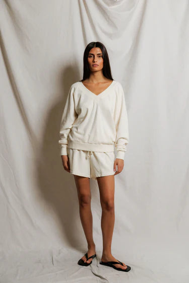 Woman wearing a white outfit against a plain background