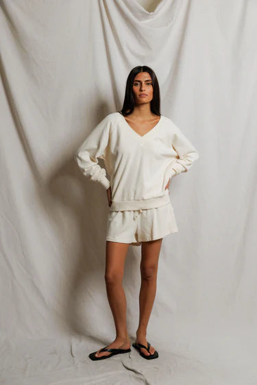 Woman wearing a white outfit against a plain white background