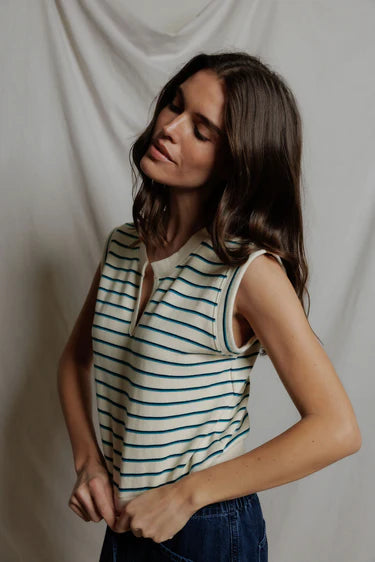 Woman wearing a striped sleeveless top against a plain background