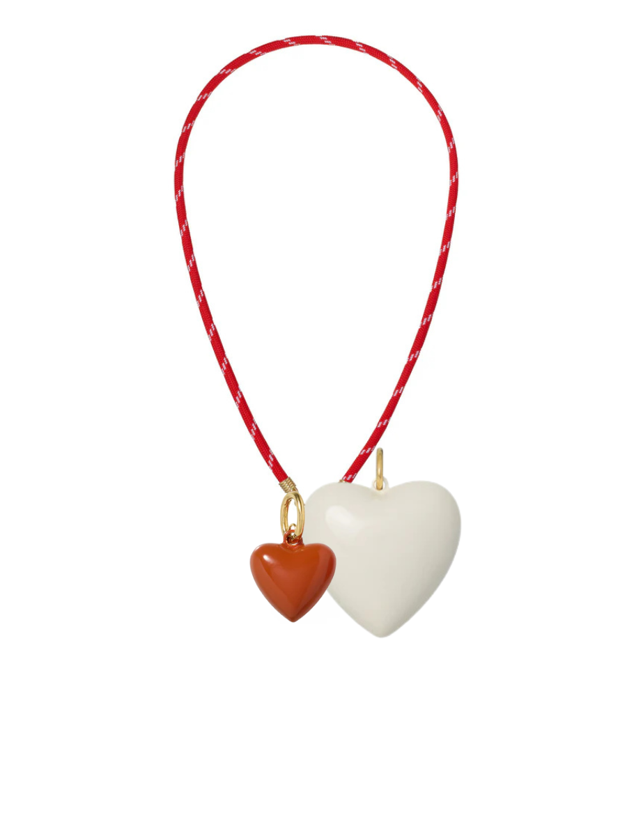 Heart-shaped pendant on a red string with a white background
