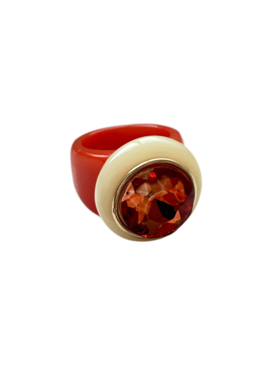 Ring with a red band and a central amber-colored gemstone on a white background
